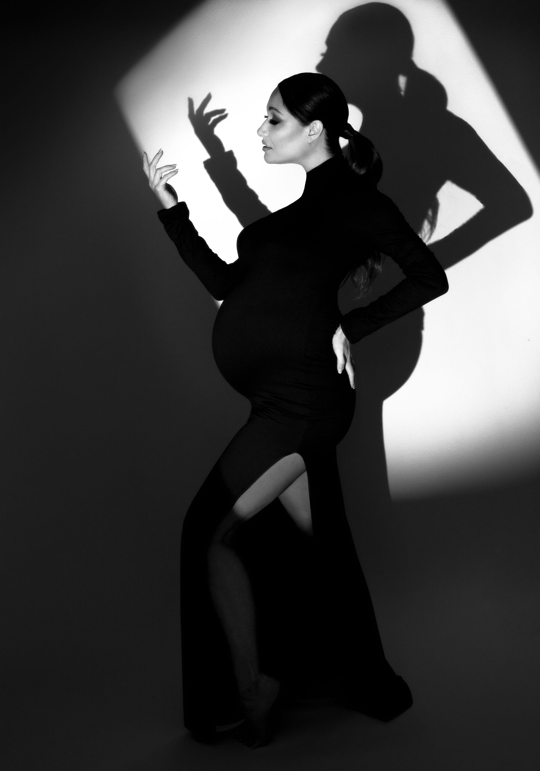 Fashion style maternity photograph of a woman in a black dress