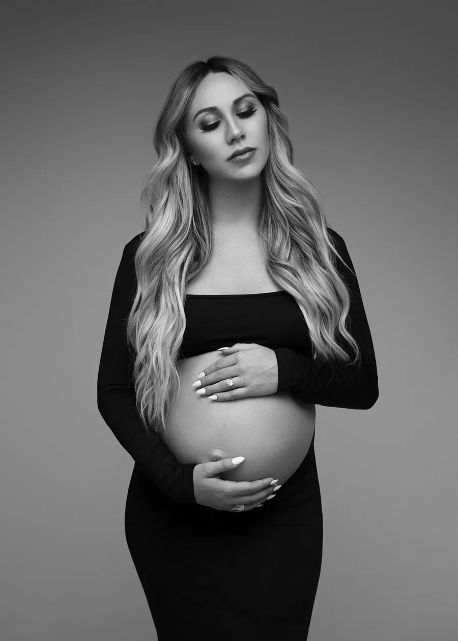 maternity portrait of a pregnant woman wearing a black dress with belly exposed taken by Andrea Liora Studios in San Francisco CA.