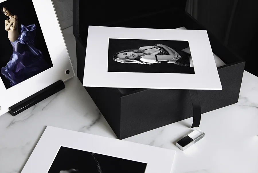 Image of a boudoir folio box with matted portrait of a woman in lingerie inside a luxury black leather box.